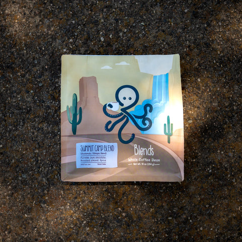 Sipnode Summit Camp Blend whole bean coffee on a natural stone surface with an outdoor-inspired setting.