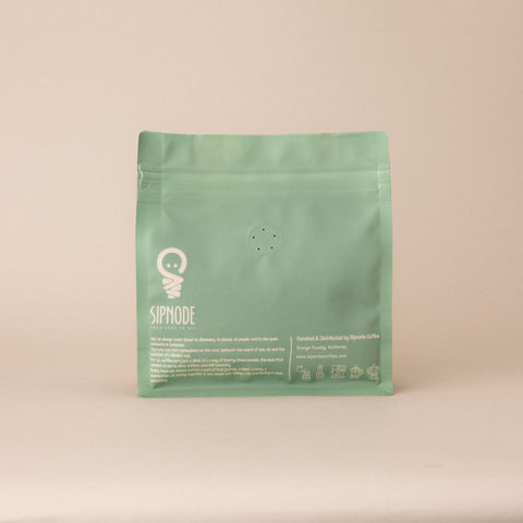 Back view of Sipnode Explorers whole bean coffee bag featuring one-way freshness valve, resealable zipper, brewing icons, and brand information.